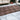 An ornate comfort Rug Wander Bloom with a floral pattern lies on a marbled floor, adding a touch of elegance to the cozy living room furnished with cream-colored sofas. Brand Name: Bubble & Blend