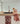 A patterned Geoweave technology Kitchen Towel Wander Bloom draped over the edge of a clean, modern kitchen counter with a mirrored backsplash reflecting the rest of the space and subtle warm-toned decor from My Store.